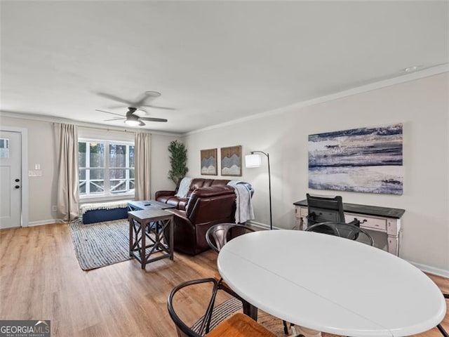 dining room featuring ceiling fan, ornamental molding, and light wood-type flooring