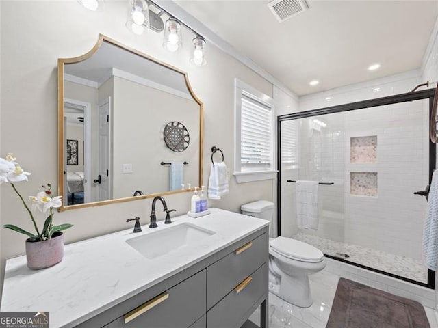 bathroom featuring vanity, a shower with shower door, ornamental molding, and toilet