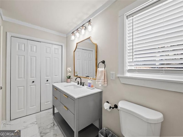 bathroom featuring vanity, ornamental molding, and toilet