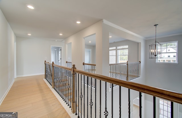 corridor featuring recessed lighting, an upstairs landing, light wood-style flooring, and crown molding