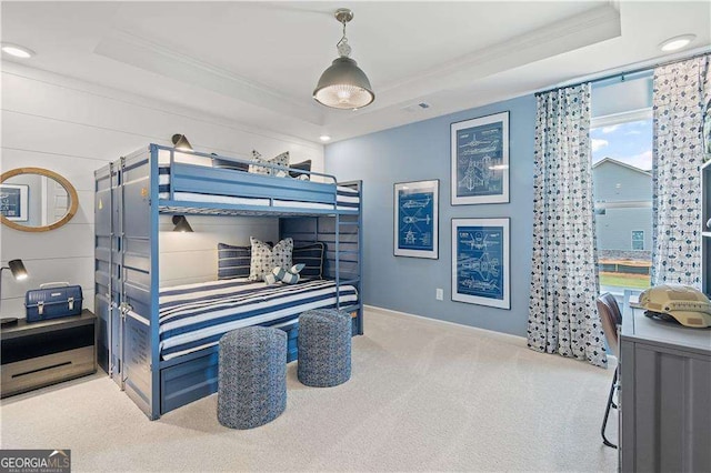 bedroom featuring ornamental molding, light carpet, and a tray ceiling