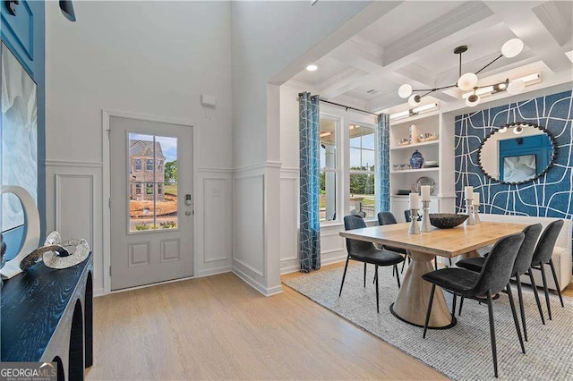 dining space with coffered ceiling, beam ceiling, light hardwood / wood-style floors, and a wealth of natural light