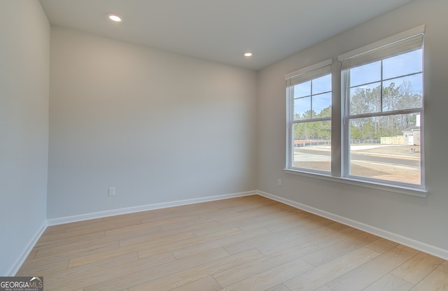 unfurnished room featuring recessed lighting, light wood-style flooring, and baseboards