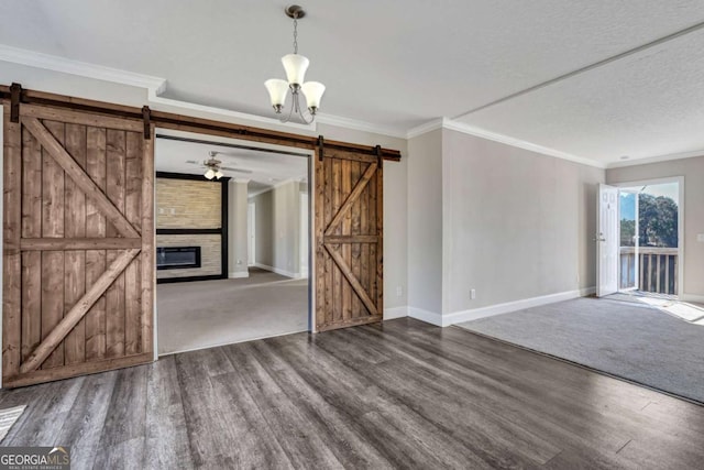 unfurnished living room with hardwood / wood-style floors, a chandelier, crown molding, a barn door, and a textured ceiling