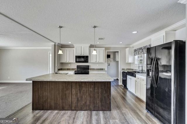 kitchen with a kitchen island, decorative light fixtures, white cabinetry, sink, and black appliances