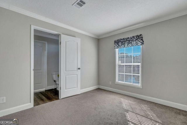 unfurnished bedroom with crown molding, dark carpet, and a textured ceiling