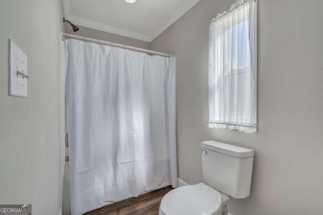 bathroom featuring hardwood / wood-style flooring, ornamental molding, toilet, and walk in shower