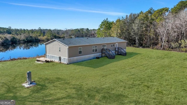 back of property with a yard and a water view