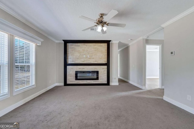 unfurnished living room featuring light carpet, crown molding, a fireplace, and ceiling fan