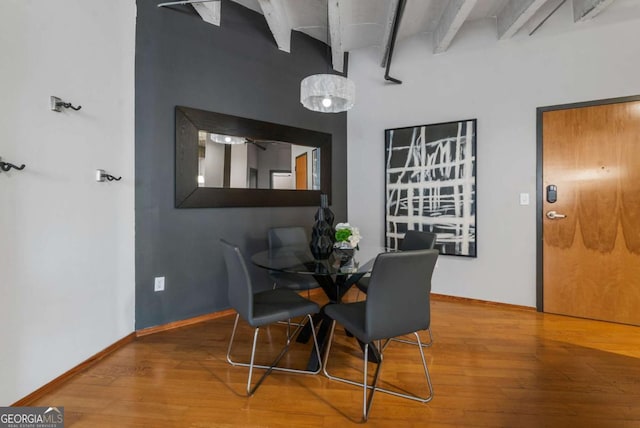 dining area with beamed ceiling and hardwood / wood-style floors