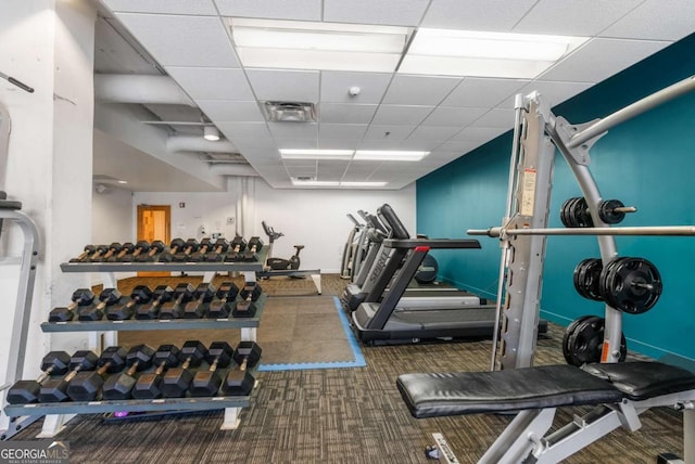 workout area featuring a drop ceiling and dark carpet