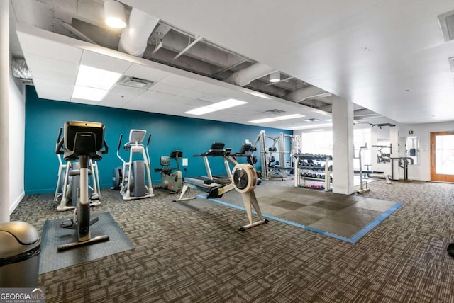 workout area featuring carpet and a drop ceiling