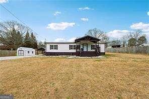 view of front of property with a front lawn and a shed