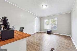 office area featuring wood-type flooring and ornamental molding