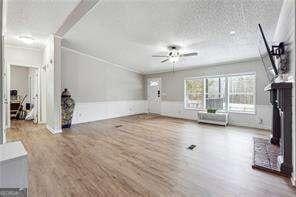 unfurnished living room featuring hardwood / wood-style flooring, a textured ceiling, and ceiling fan