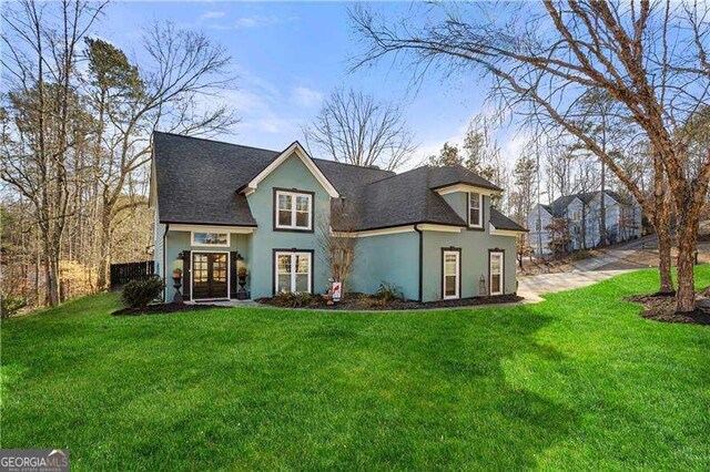 rear view of property featuring a lawn