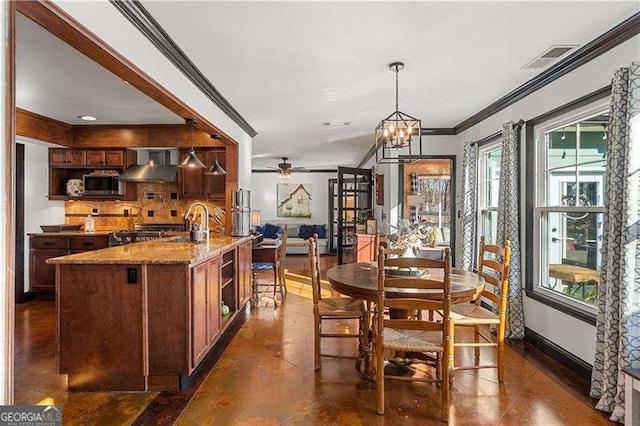 dining space featuring ceiling fan with notable chandelier, ornamental molding, and sink