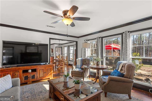 living room with ornamental molding, plenty of natural light, and ceiling fan