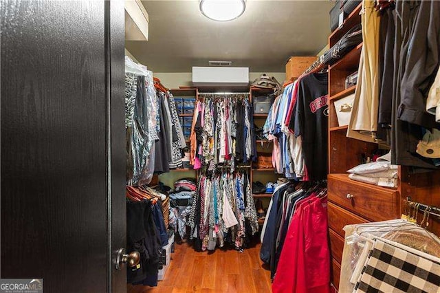 walk in closet with light hardwood / wood-style floors