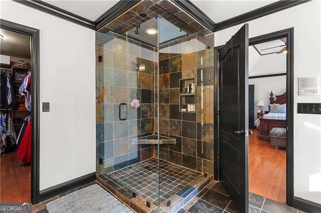 bathroom featuring crown molding, wood-type flooring, and walk in shower