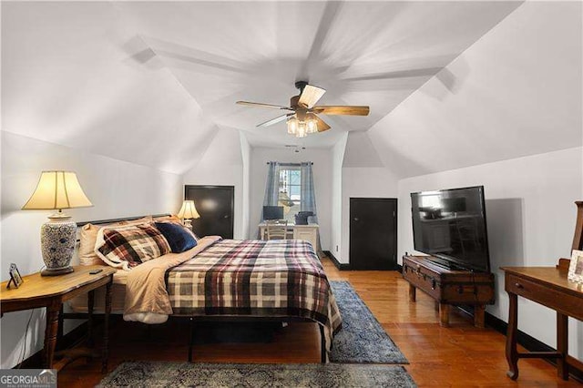 bedroom with ceiling fan, vaulted ceiling, and wood-type flooring