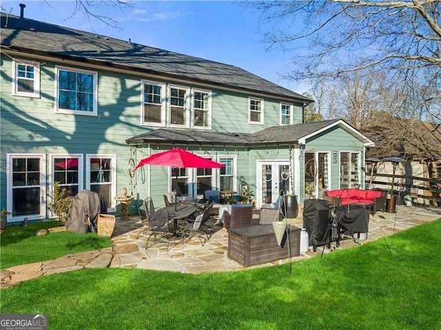 rear view of house with a yard and a patio area