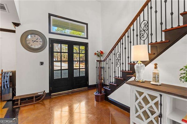 entrance foyer featuring a towering ceiling and french doors