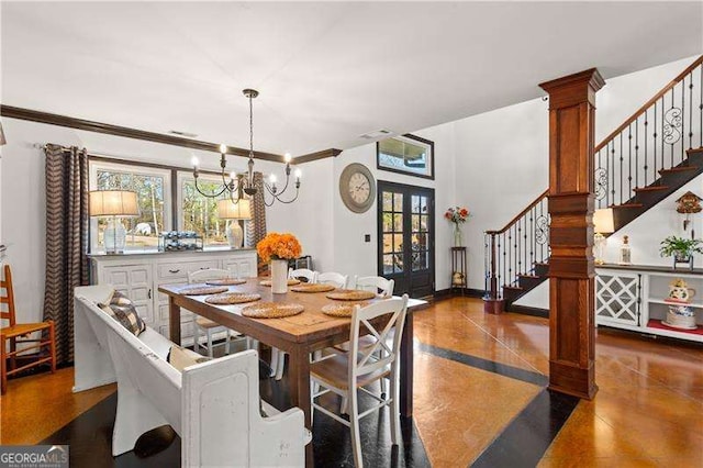 dining area with french doors, crown molding, and a chandelier