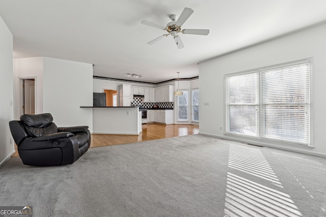 carpeted living room featuring ceiling fan