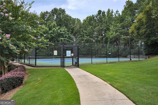 view of tennis court with a lawn