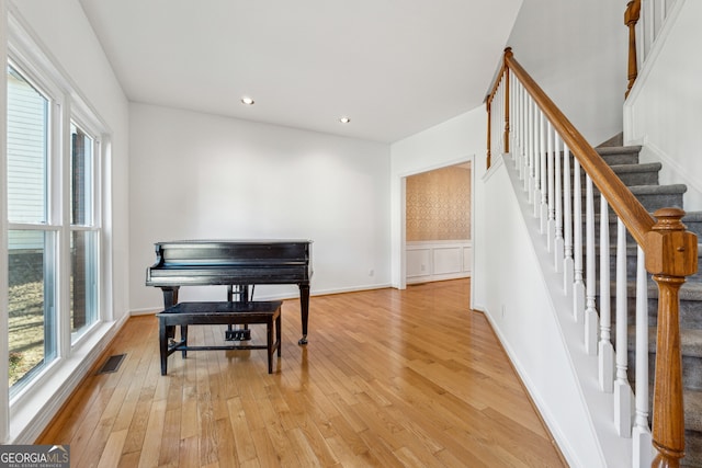 living area with a wealth of natural light and light hardwood / wood-style floors