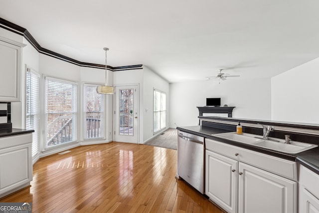 kitchen with decorative light fixtures, dishwasher, sink, white cabinets, and light hardwood / wood-style flooring