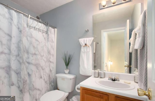 bathroom featuring a shower with curtain, vanity, and toilet