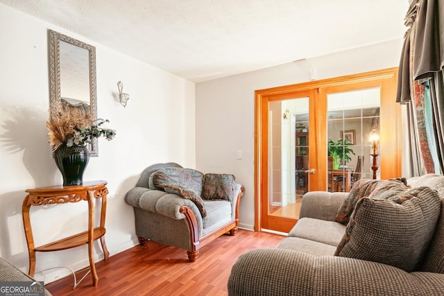 living area with light hardwood / wood-style flooring and french doors