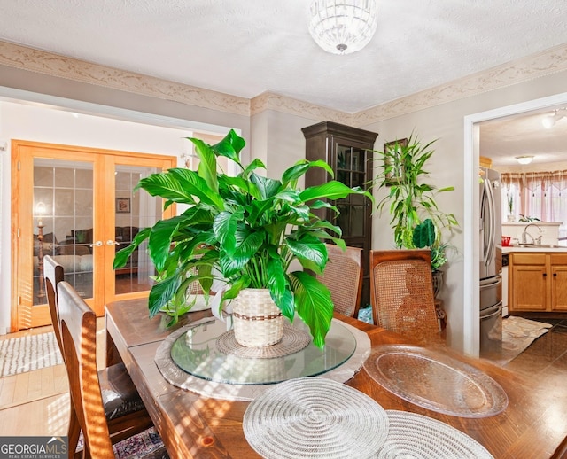 dining room with sink, tile patterned floors, a textured ceiling, and french doors