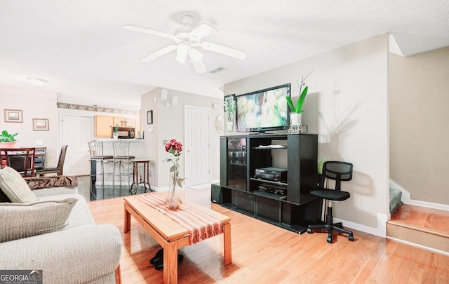 living room featuring ceiling fan and light hardwood / wood-style floors