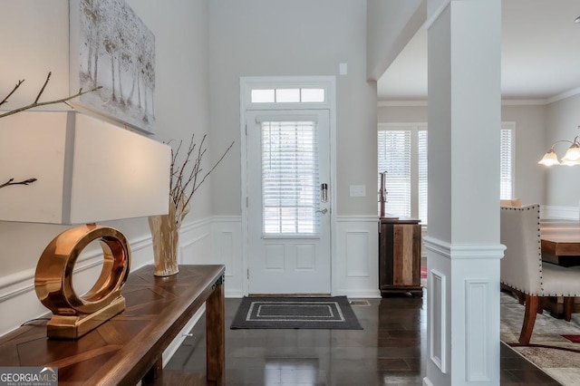 entryway with ornamental molding, dark hardwood / wood-style flooring, and an inviting chandelier