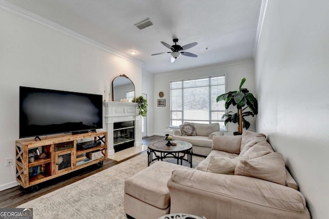 living room with crown molding, ceiling fan, and dark hardwood / wood-style flooring