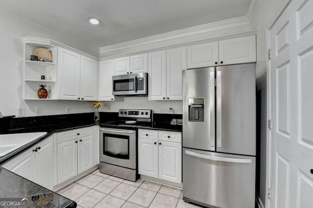 kitchen with ornamental molding, light tile patterned flooring, white cabinets, and appliances with stainless steel finishes