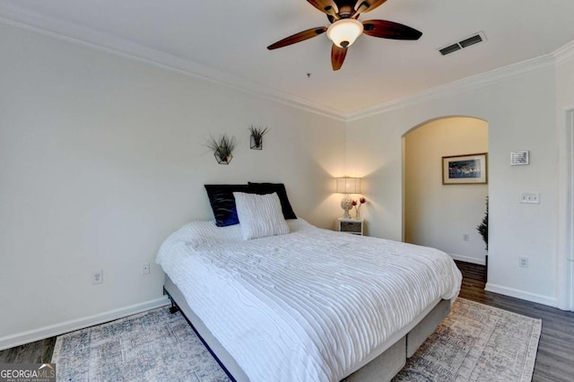 bedroom with crown molding, ceiling fan, and wood-type flooring