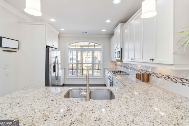 kitchen featuring sink, white cabinets, decorative backsplash, stainless steel appliances, and light stone countertops