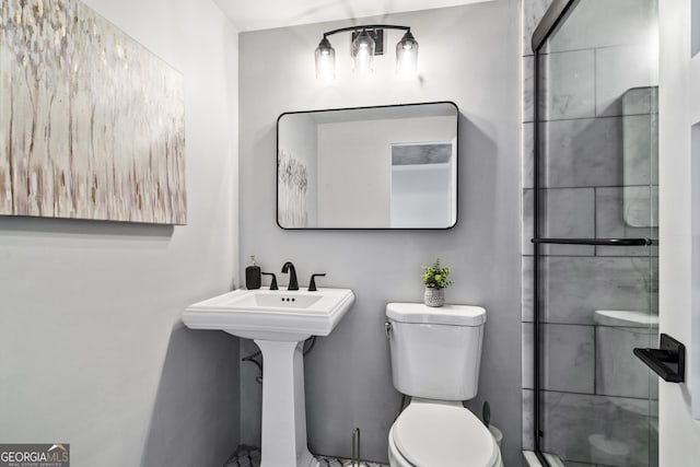 bathroom featuring toilet and a shower with door