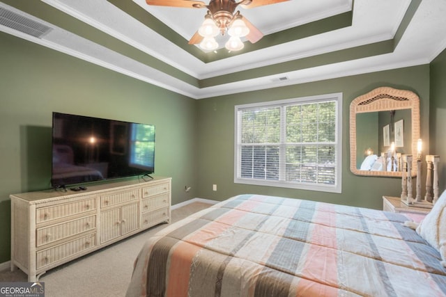 bedroom with light colored carpet, ornamental molding, and a raised ceiling