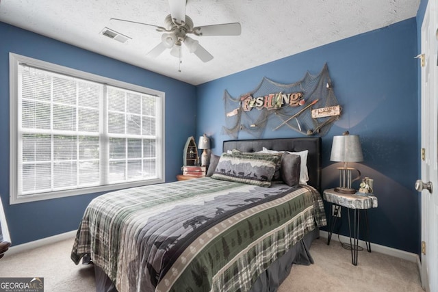 carpeted bedroom featuring ceiling fan and a textured ceiling