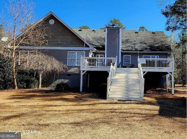 rear view of house featuring a lawn and a deck