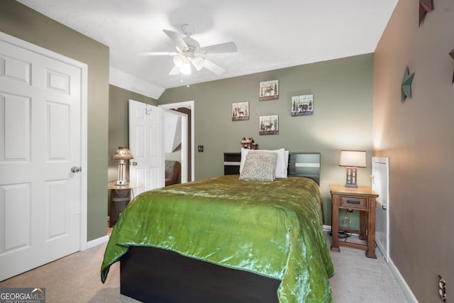 bedroom with lofted ceiling, light colored carpet, and ceiling fan