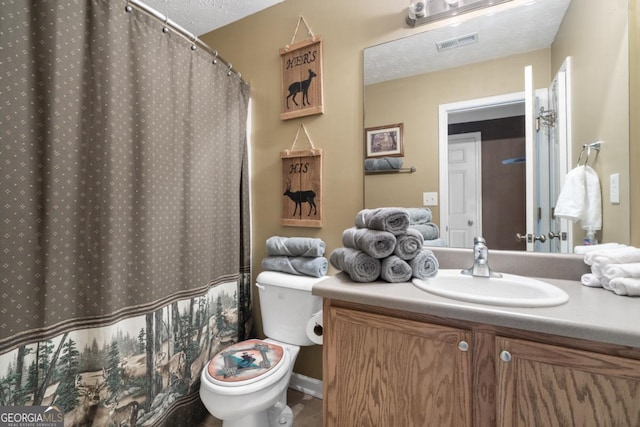 bathroom featuring vanity, toilet, and a textured ceiling