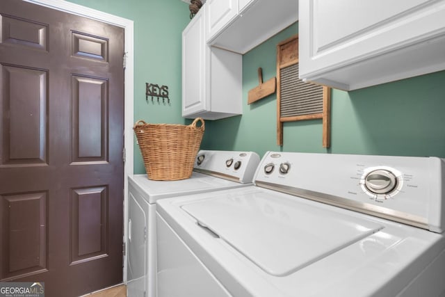 washroom with cabinets and washer and dryer