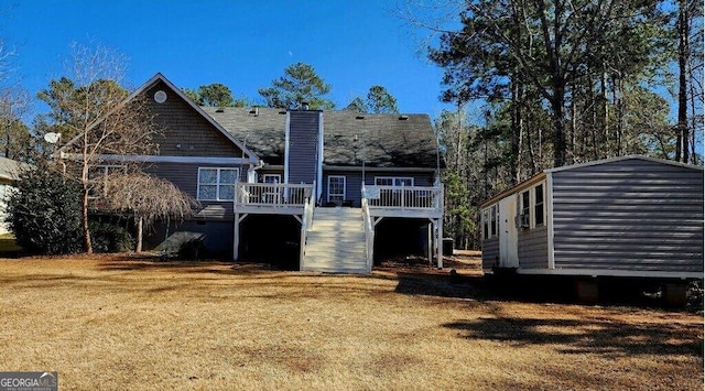 back of property featuring a wooden deck and a lawn