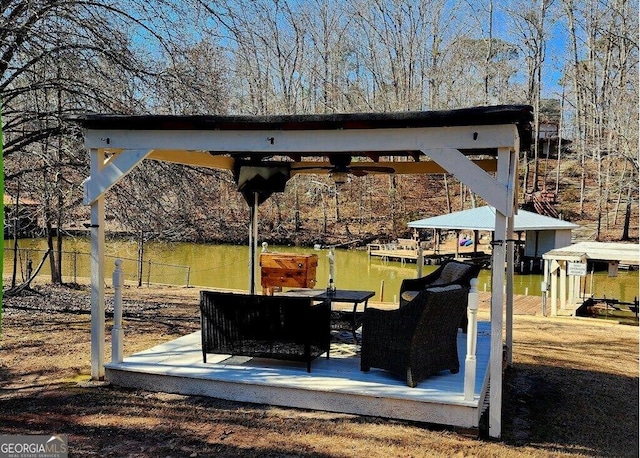 view of patio with a gazebo, a boat dock, and a water view